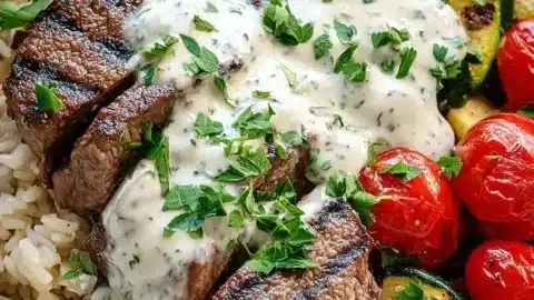Grilled steak bowl with creamy sauce and grilled zucchini on a plate