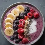 Delicious berry protein smoothie in a glass with fresh berries and protein powder.
