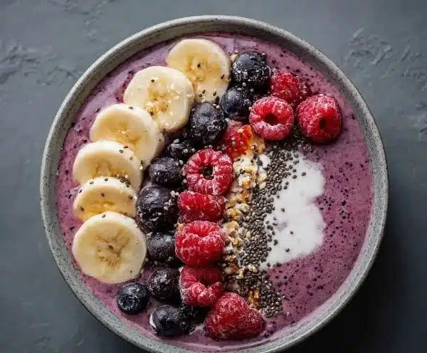 Delicious berry protein smoothie in a glass with fresh berries and protein powder.