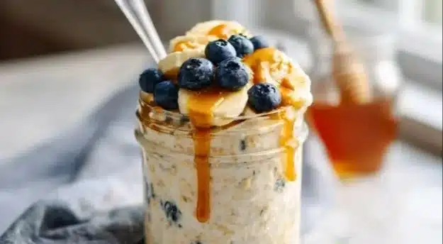 Bowl of creamy overnight oats topped with fresh fruits and nuts