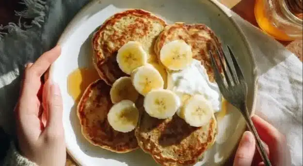 Stack of fluffy protein pancakes topped with fresh berries and maple syrup