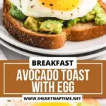 Avocado toast topped with a perfectly cooked egg on a wooden table