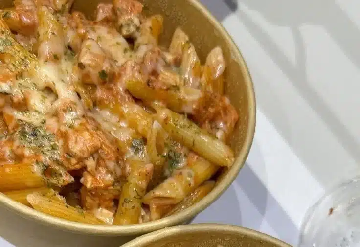 Baked chicken thigh pasta served with fresh herbs and vegetables